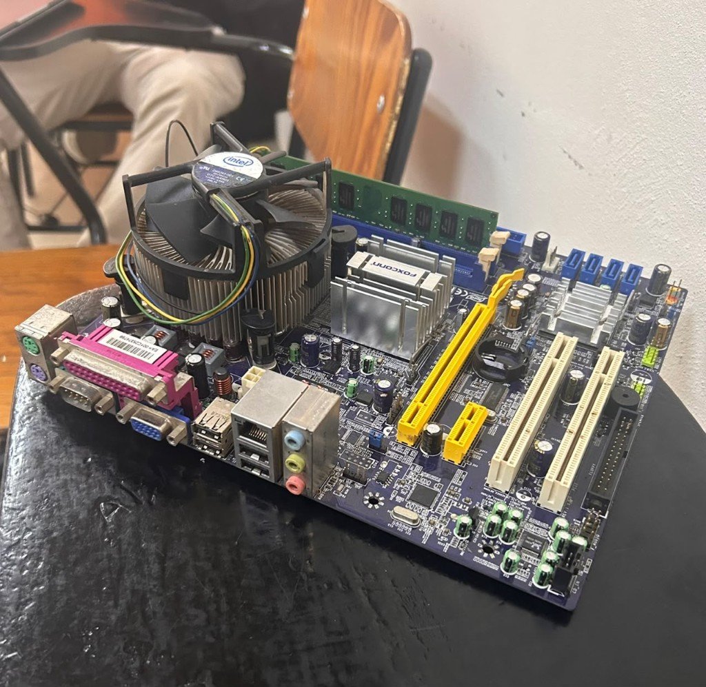 Fotografía de una placa madre con ventilador Intel, memoria RAM, disipador Foxconn y conectores traseros